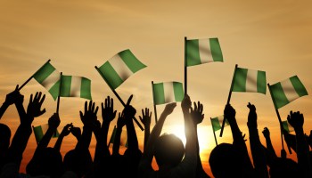 Group of People Waving Flag of Nigeria in Back Lit