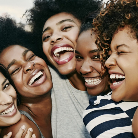 Women laughing together on urban rooftop