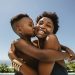 Boy kissing on cheeks of her mother. Cute boy hugging his smiling mother and kissing in her face.